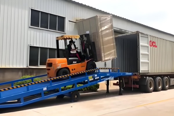 移动登车桥正在连接地面与高栏货车叉车正好行驶在桥面上的实拍图